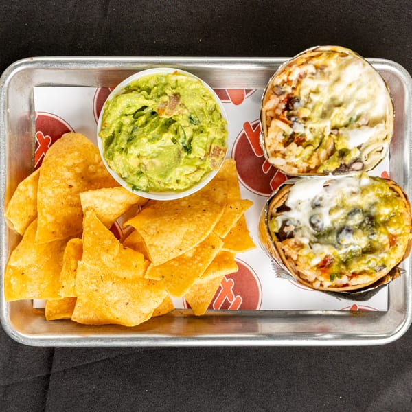 BTB Burrito's tray with two burritos, a bowl of guacamole, and tortilla chips.