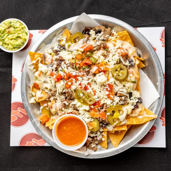 BTB Burrito's loaded nachos with meat, cheese, jalapeños, pico de gallo, and a side of guacamole and salsa.