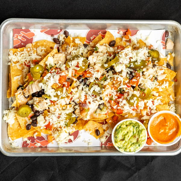 BTB Burrito's loaded nachos with cheese, jalapeños, black beans, salsa, and sides of guacamole and queso.